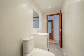 Bathroom with square white porcelain sink with square frameless mirror and mahogany wood door