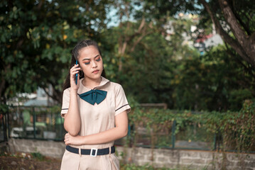 An upset asian high school student listens to her boyfriends apology after a fight over the phone....