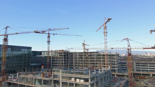 Aerial view around a large construction site with many cranes - orbit, drone shot