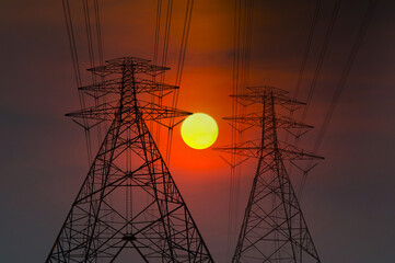Big SUN between Silhouette street light post, electric pole and high voltage tower.High voltage transmission pole against morning sun background.