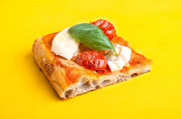 Piece of pizza al taglio on plane yellow background