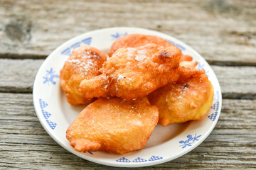 Traditional home made deep fried  patties  covered with sugar  оn rustic backgroud.Mekitsa or Mekica,  on wooden  rustic  background. Made of kneaded dough that is deep fried  .Carnival tortelli stuff