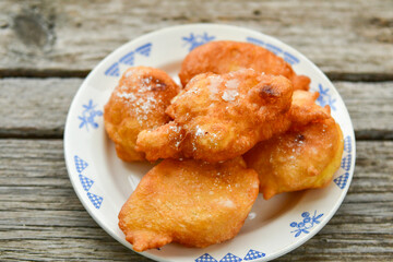 Traditional home made deep fried  patties  covered with sugar  оn rustic backgroud.Mekitsa or Mekica,  on wooden  rustic  background. Made of kneaded dough that is deep fried  .Carnival tortelli stuff