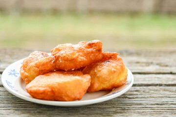 Traditional home made deep fried  patties  covered with sugar  оn rustic backgroud.Mekitsa or Mekica,  on wooden  rustic  background. Made of kneaded dough that is deep fried  .Carnival tortelli stuff