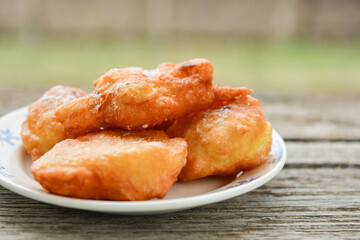 Traditional home made deep fried  patties  covered with sugar  оn rustic backgroud.Mekitsa or Mekica,  on wooden  rustic  background. Made of kneaded dough that is deep fried  .Carnival tortelli stuff