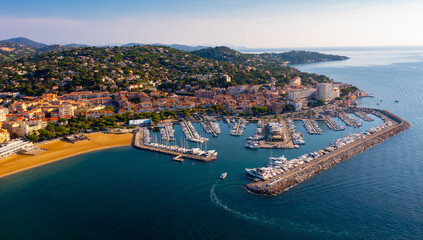 Aerial panoramic view of French commune of Sainte-Maxime on shore of Gulf of Saint-Tropez overlooking large marina on sunny summer day, Var department