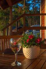 A glass of white wine is on the table, summer, warm evening.
