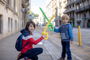 Cute little child tourist, holding balloon made as a sword, admiring Barcelona city, family travel...