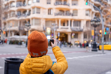 Child, posing in front of Casa Mila in Barcelona - obrazy, fototapety, plakaty