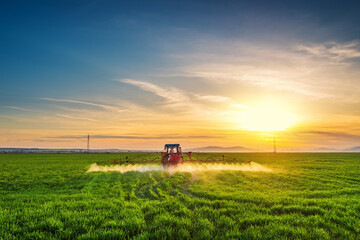 Tractor spray fertilizer spraying pesticides on green field, agriculture background concept.