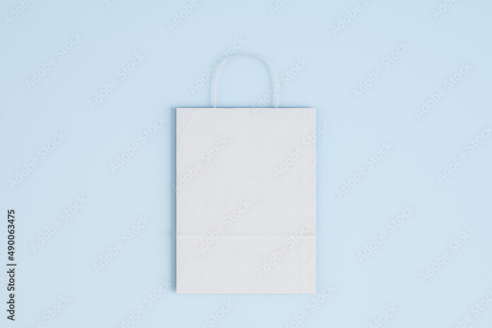 Poster close up of empty white paper bag on blue background. shopping concept. mock up, 3d rendering.