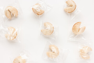 Fresh and tasty Chinese fortune cookies, individually wrapped in foil on white background. Top view, copy space