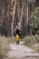 Obraz premium Photo of a girl dressed as a national American. Walk and rest in the summer forest. Entertainment. The game. Fun. Wear a jacket, khaki dress and bright yellow tights. Happy woman.