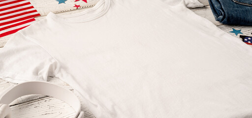 Mockup design white t shirt for logo, high angle view on white wooden background with US flag,...