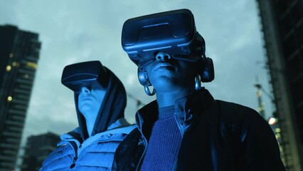 Man and woman with VR goggles in city at night, Italy - Powered by Adobe