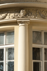 Obraz premium A part of the facade of an old building with beautiful stucco decoration and bas-relief head of the mythical man