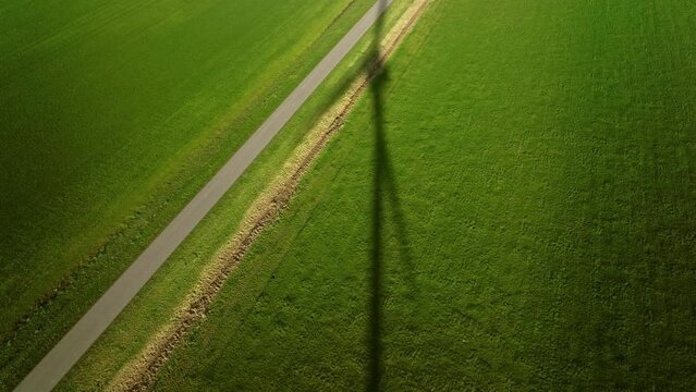 Shadow of rotating wind turbine in green field, Swifterbant, Netherland