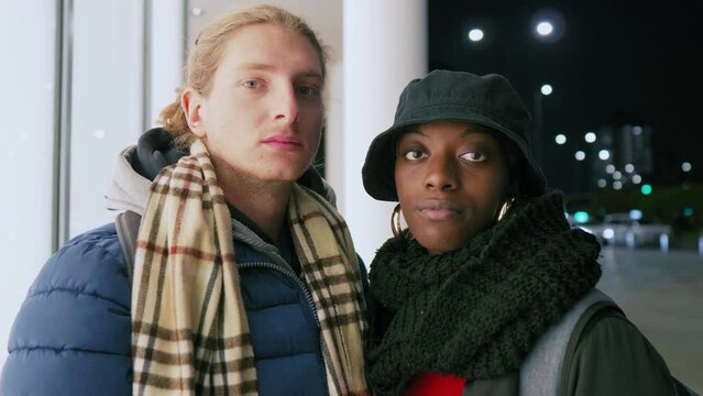 Portrait of young couple standing in city at night, Italy
