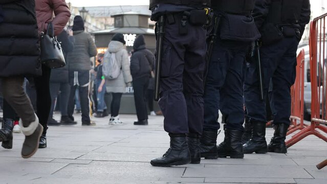 police officers in uniforms with batons and pistols at a rally against the war between russia and ukraine. slogans no war. protests and detentions