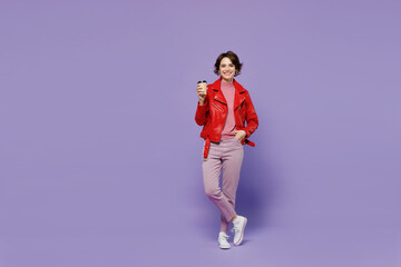 Full body young smiling satisfied happy woman 20s wear red leather jacket hold takeaway delivery craft paper brown cup coffee to go isolated on plain pastel light purple background studio portrait