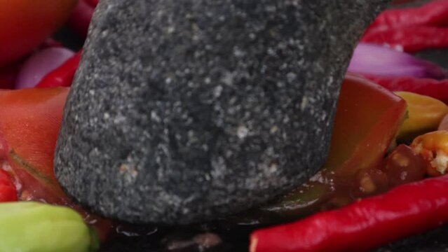 mashing tomato in a stone masher stock video