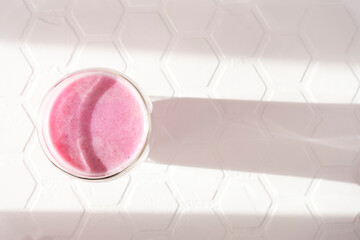 Pink rose milk in a double walled glass. Healthy drink moon milk. Top view.