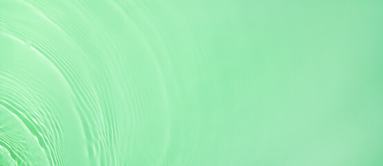 Abstract summer banner background Transparent green clear water surface texture with ripples and splashes. Water waves in sunlight with copy space Cosmetics moisturizer micellar toner emulsion