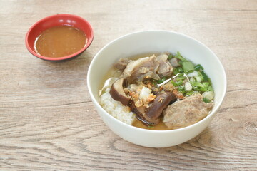 boiled rice with pork bone and slice black mushroom in soup on bowl