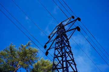 Looking up at a power pylon with blue sky background