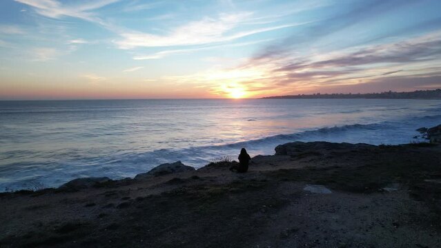 Rising image of a girl watching the sunset at Cascais coast,Portugal