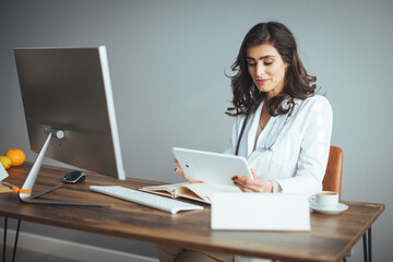 Confident female doctor sitting at office desk, health care and prevention concept. Portrait of...