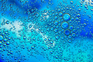 Bubbles in oil in water on blue and white colour abstract background.