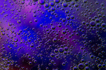 Bubbles in oil in water on blue, turquoise and purple colour abstract background