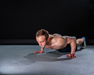 Obraz premium Man on black background keeps dumbbells pumped up in fitness bodybuilding biceps torso, arm training man male pectoral. Attractive adult, people fit