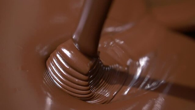 Close-up stirring chocolate, hot melted liquid chocolate.
