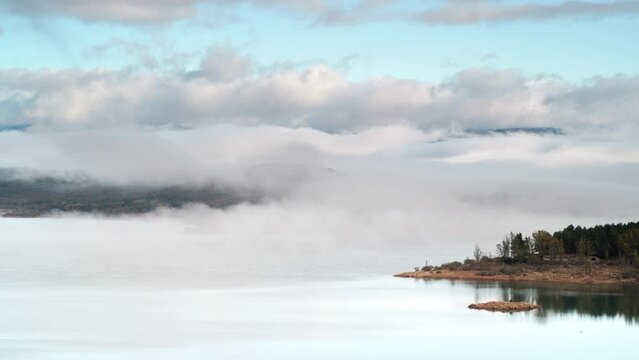 Morning landscape. Time lapse of fog and clouds moving over lake Embalse de Aguilar de Campoo in province of Palencia, Castile and Leon community, northern Spain.
