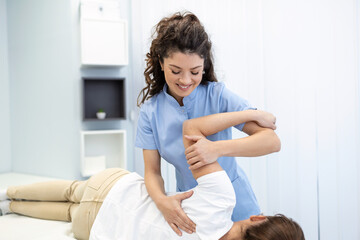 Physiotherapist treatment patient. Holding patient's hand, shoulder joint treatment. Physical Doctor consulting with patient About Shoulder muscule pain problems Physical therapy diagnosing concept - obrazy, fototapety, plakaty