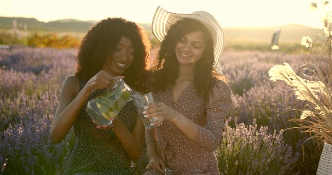 Women drink lemonade in the lavender field