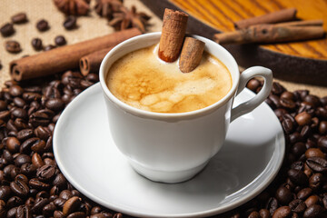 Espresso coffee with cinnamon on the background of coffee beans. Cinnamon stick in a cup of coffee. tonic drink