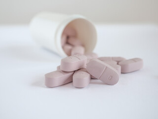 White dose of pink pills on white background. Copy space.