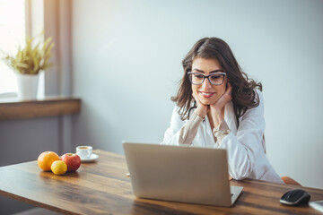 Female nutritionist provides patients with online consultations while sitting in her office. Woman...