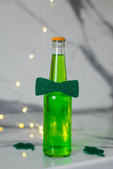 Green beer and lemonade in a bottle with a butterfly. St. Patrick's Day. Vertical photo.