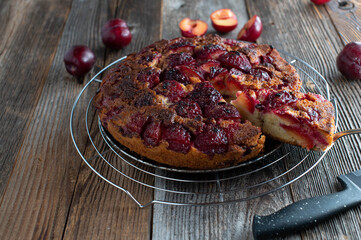 Plum cake baked upside down on a cooling rack