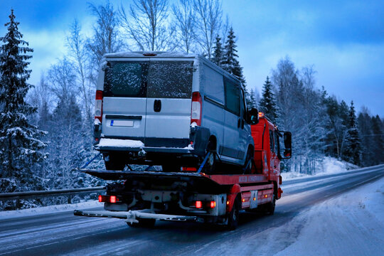 Mercedes-Benz Atego Tow Truck Carrying Breakdown Van along Highway at Dusk in Winter, Rear View. 