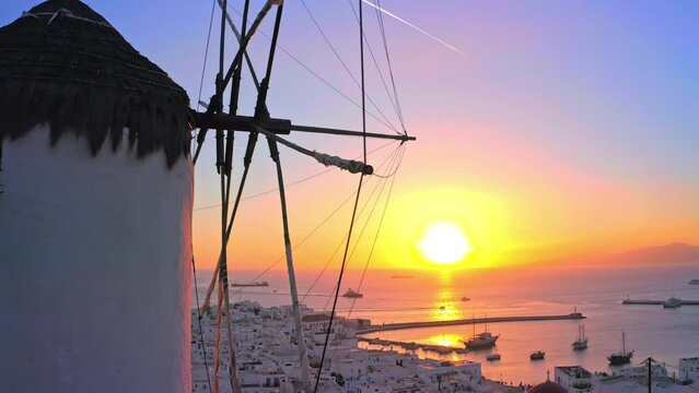 Scenic sunset of mediterranean sea of Mykonos island. Traditional greek windmill