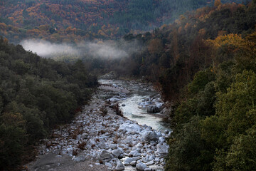 Rivière presqu'à sec en automne dans la brume du matin au fond d'une vallée sauvage dans la...