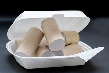 Empty rolls from toilet paper lying in a package of fast food. Background on the theme of ecology and recycling of materials.