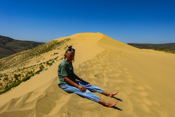 A girl on the sand dunes of Sarykum. The desert in Dagestan. Russia. 2021.