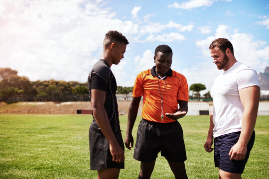 It All Comes Down To The Coin Toss. Shot Of A Referee Flipping A Coin Before A Rugby Game.