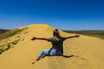 A girl on the sand dunes of Sarykum. The desert in Dagestan. Russia. 2021.